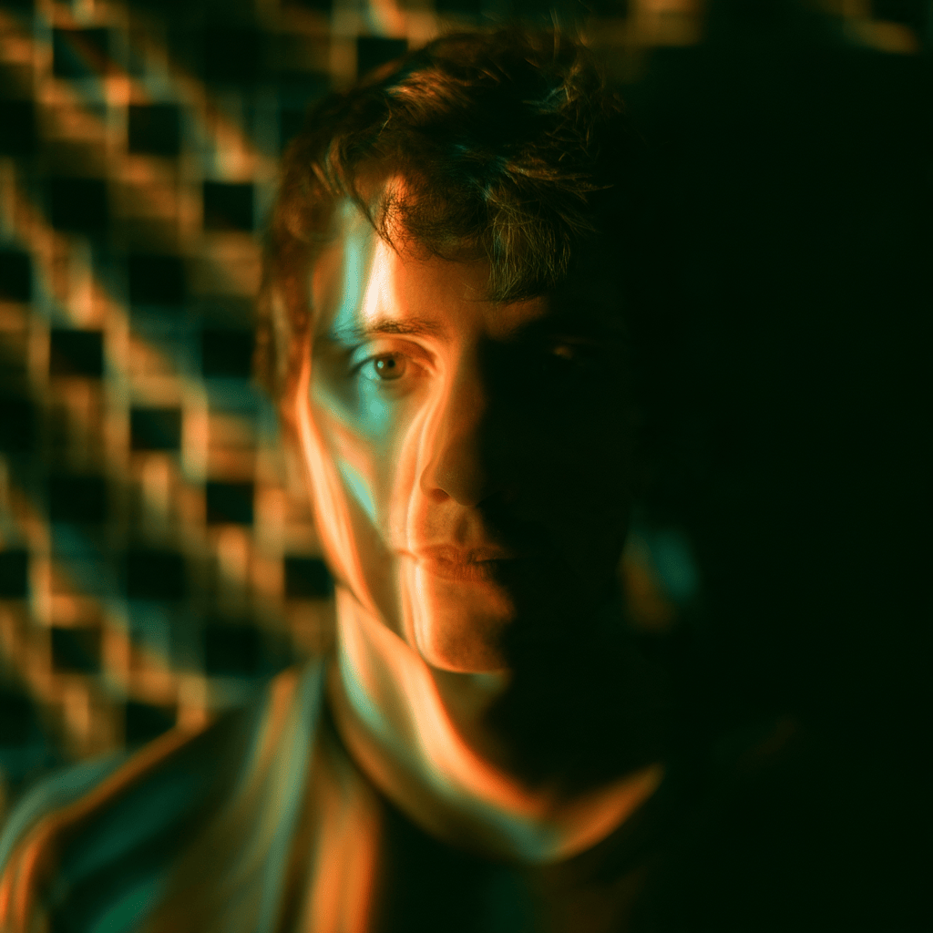 Retrato de una persona con luz ambiental que crea un efecto de distorsión en su rostro, fondo con patrón abstracto.